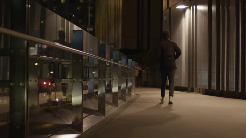 A man walks in a city at night