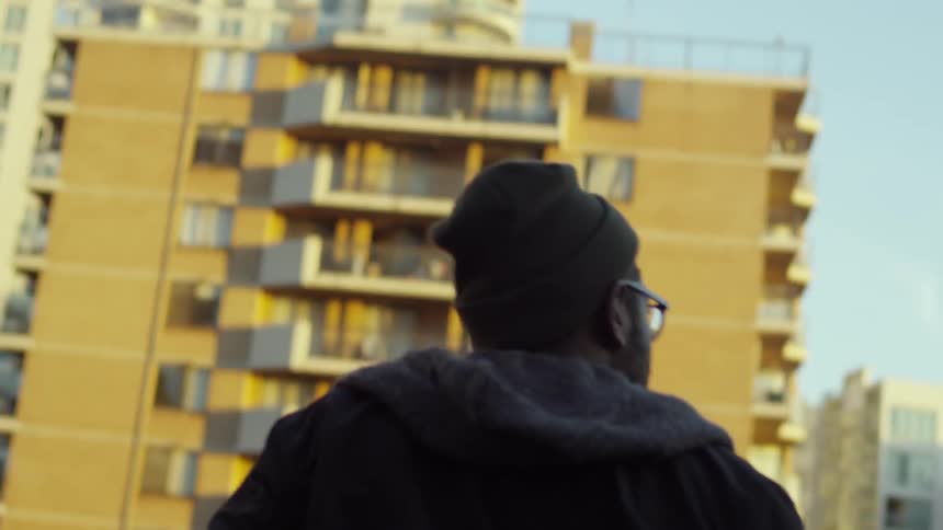 An angry looking man walks on the top of a parking ramp roof