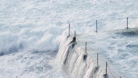 Waves crash on a platform covering it with water