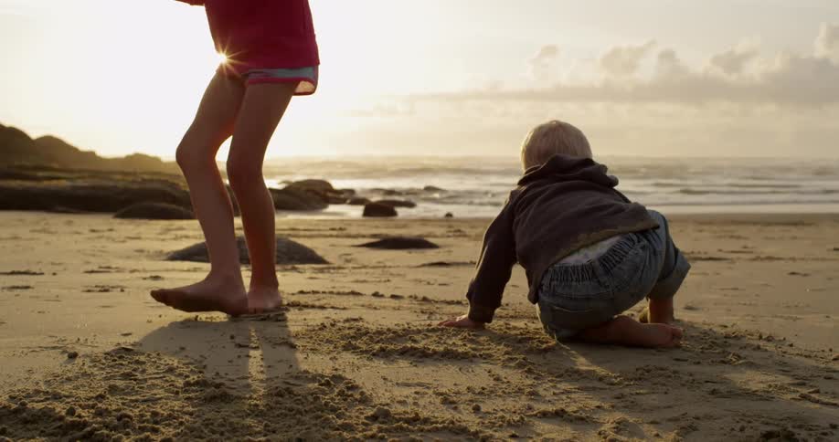 A girl does a handstand on the beach