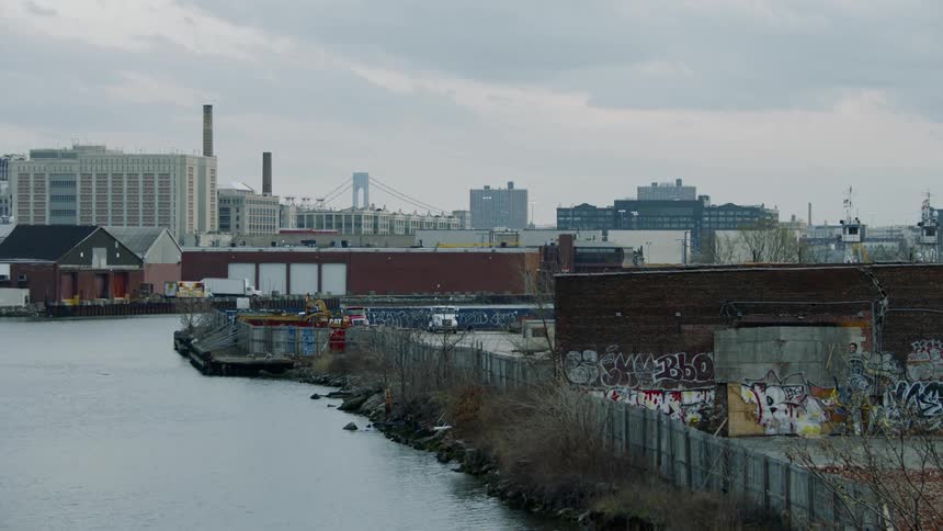 A graffiti covered building sits next to a body of water