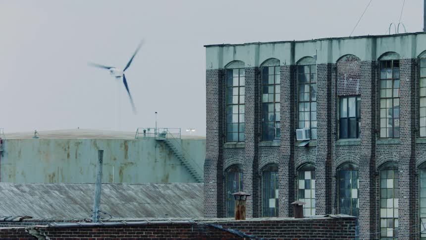 A building in front of a wind turbine