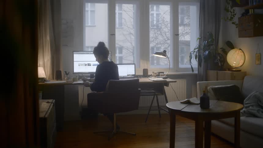 A woman is sitting on a chair in her home office