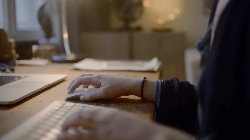 Woman sitting at the desk uses desktop in the room