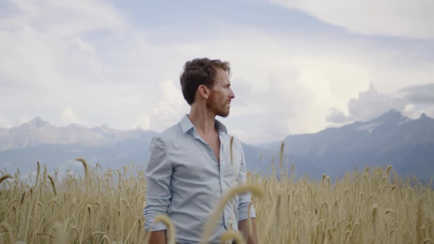 Man standing in a wheat field looking off to the side