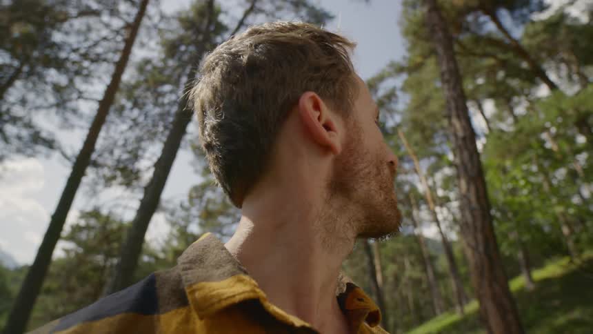 Man standing in middle of forest looking around