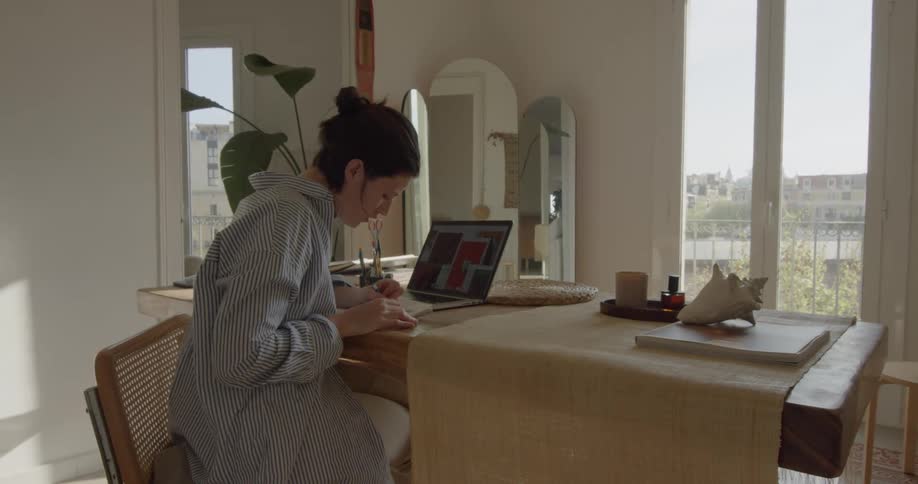 A woman writes while sitting at her desk