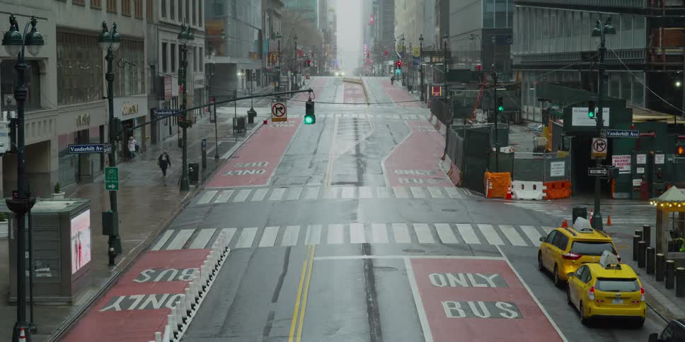 A city streets with vehicles and people walking on the sidewalk