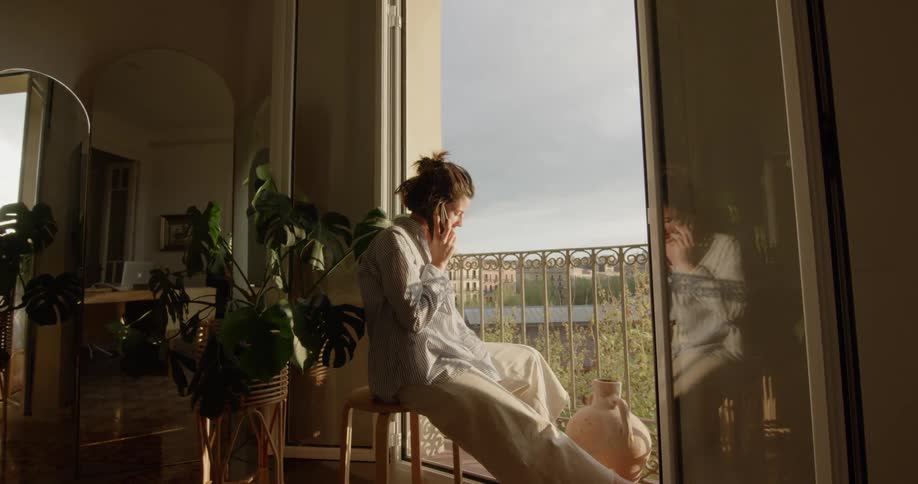 A woman on her phone at the window