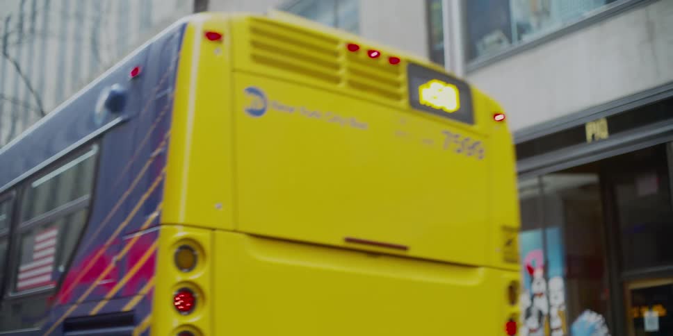 A city bus pulls away from the curb