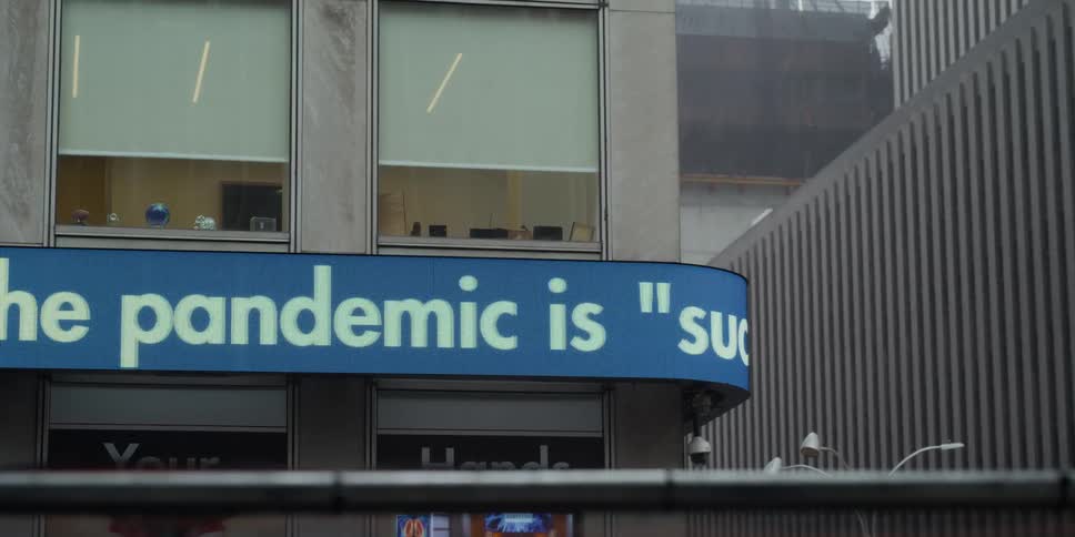 A ticker type sign scrolls around the outside of a building