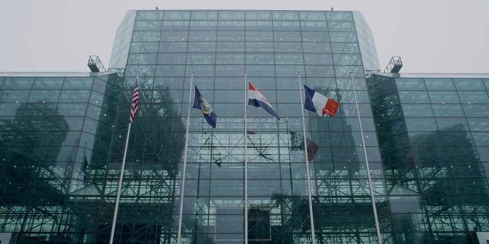 Flags wave in the breeze in front of a large office building