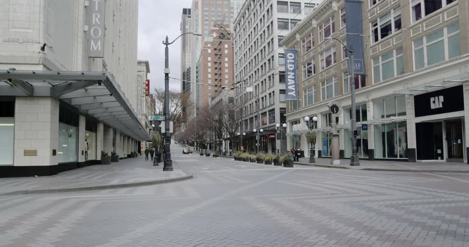 Cars drive through an intersection in a large city