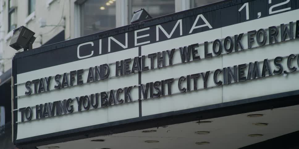 A sign on a movie theater encourages people to be safe