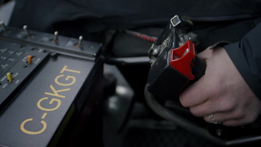 A white man grips a helicopter throttle