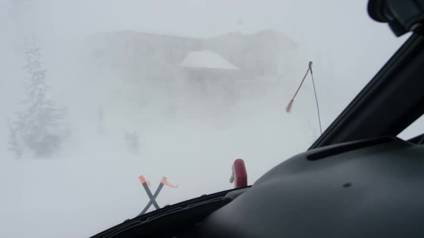 A helicopter lands in a whiteout outside of a building
