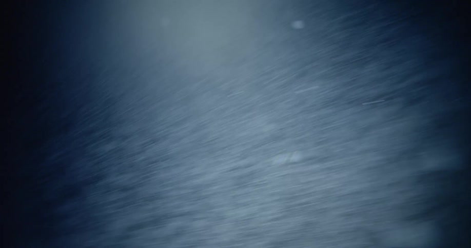 Heavy snow rushing past camera in the dark