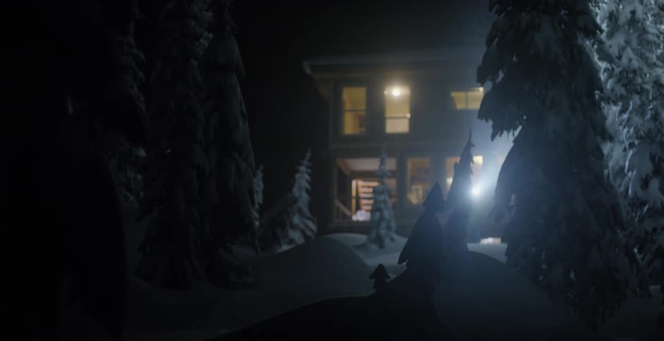 A person walks outside of a cabin in the winter shining a flashlight