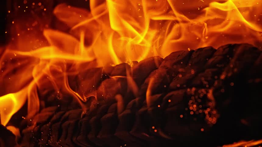 Flames rise from a rotating log