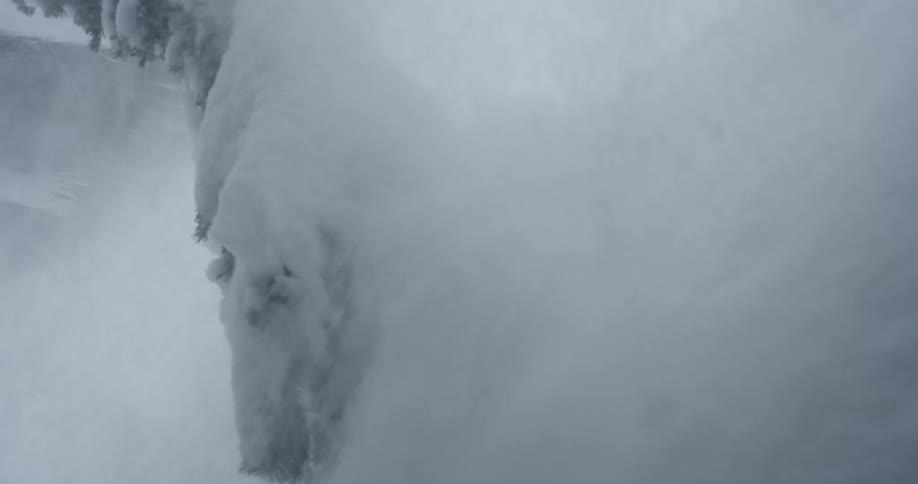An avalanche sends snow falling down a slope