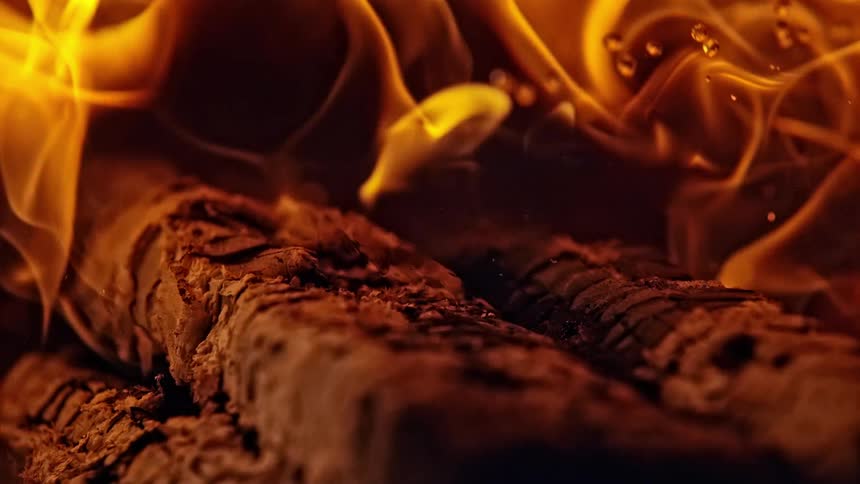 Wooden logs smoldering and burning with large flames
