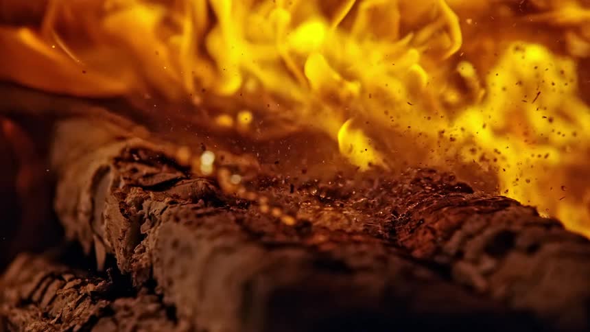 An accelerant is poured onto wood and a fire grows on the wood