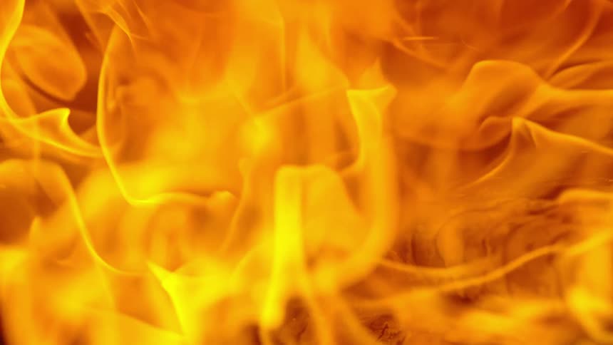 Orange flames rise from wooden logs