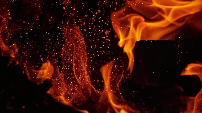 Sparks and embers fly around in a fire