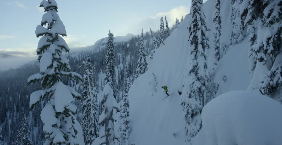 A skier does a big 360 over a steep slope