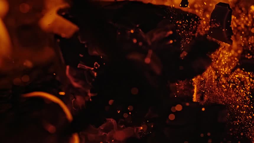A burning hunk of wood explodes into embers