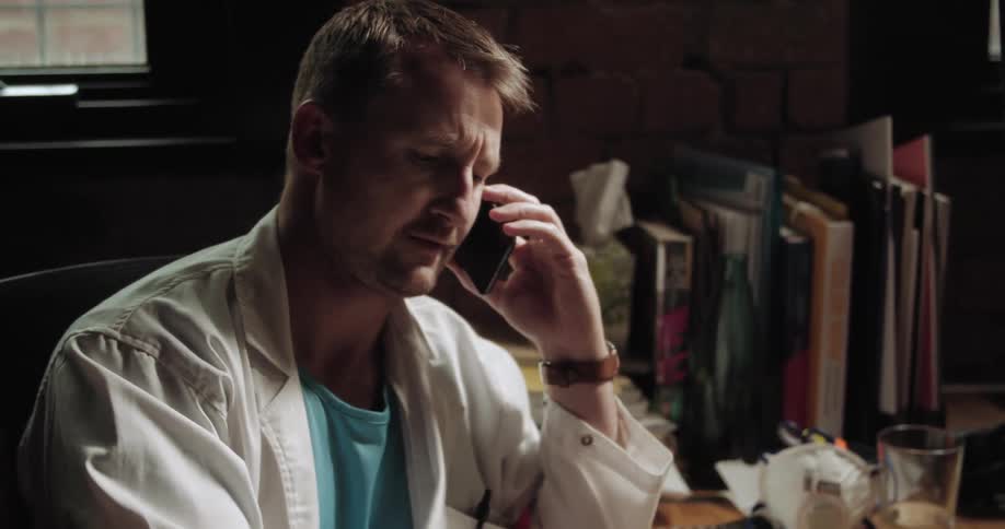 A man is talking on the phone and writing things down