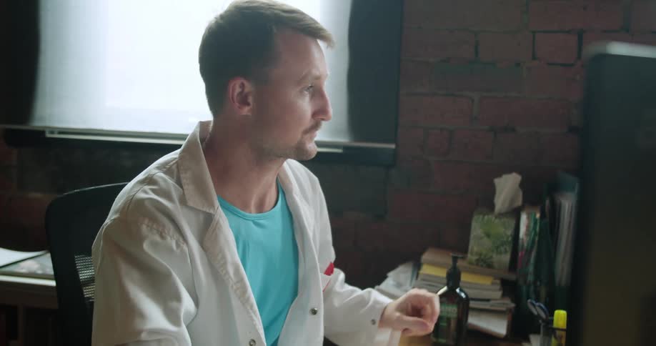 Doctor sitting at the desk uses desktop in the office
