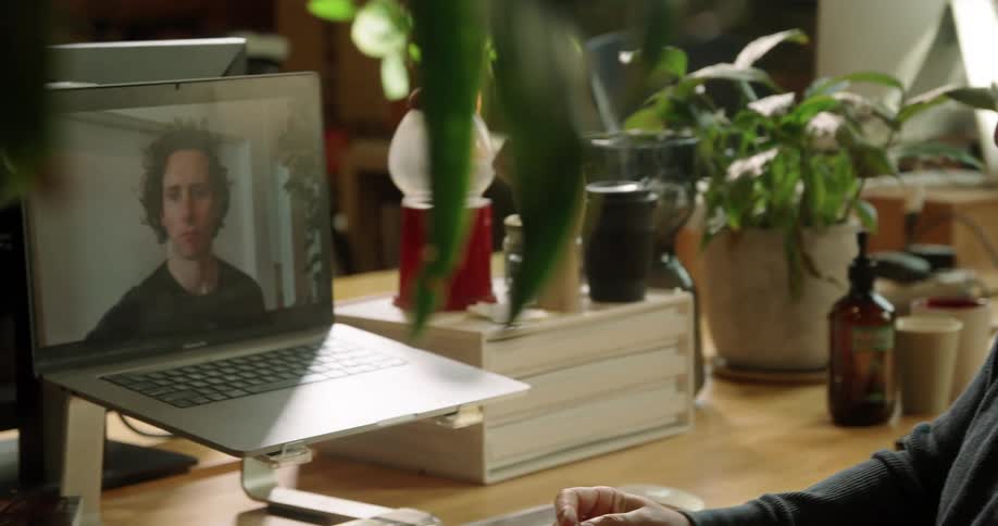 Man teleconferences while sitting at table