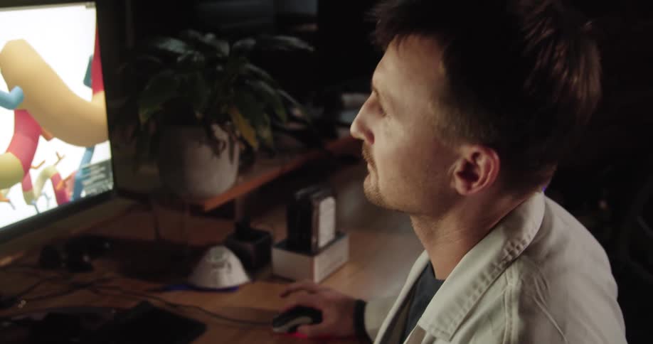 A man writes at his desk and uses his computer