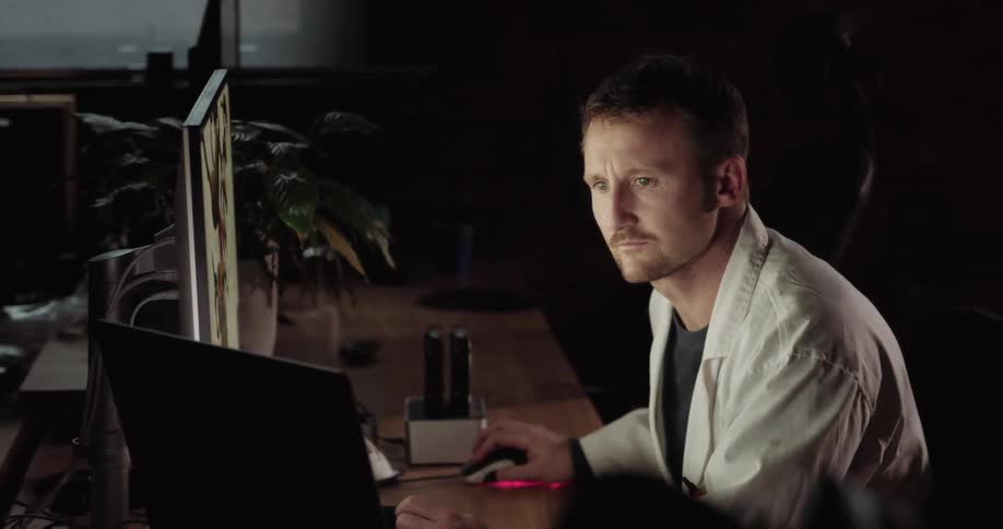 A male doctor stares at a computer monitor