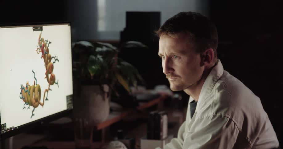 Doctor reviews molecule graphics on monitor