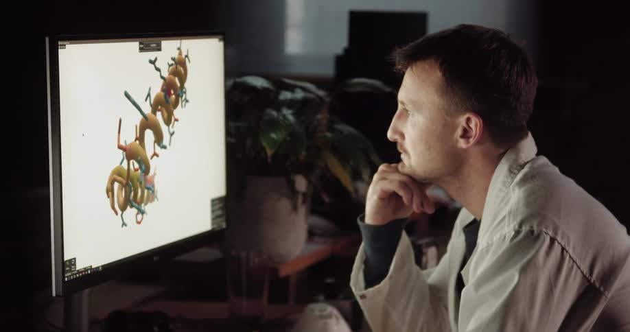 Doctor sitting at the table uses desktop in the office at night
