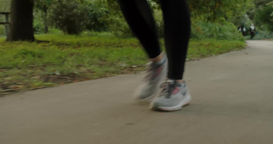 Woman walks along the road in the public park