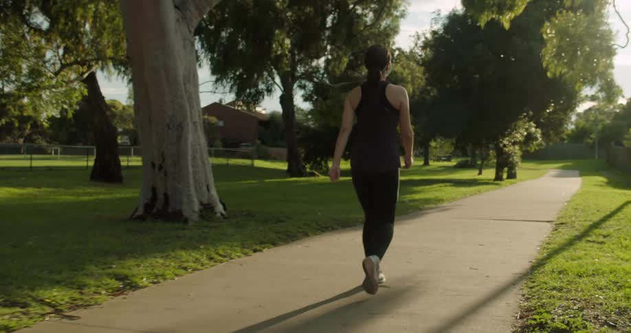 Woman jogging on park at sunrise