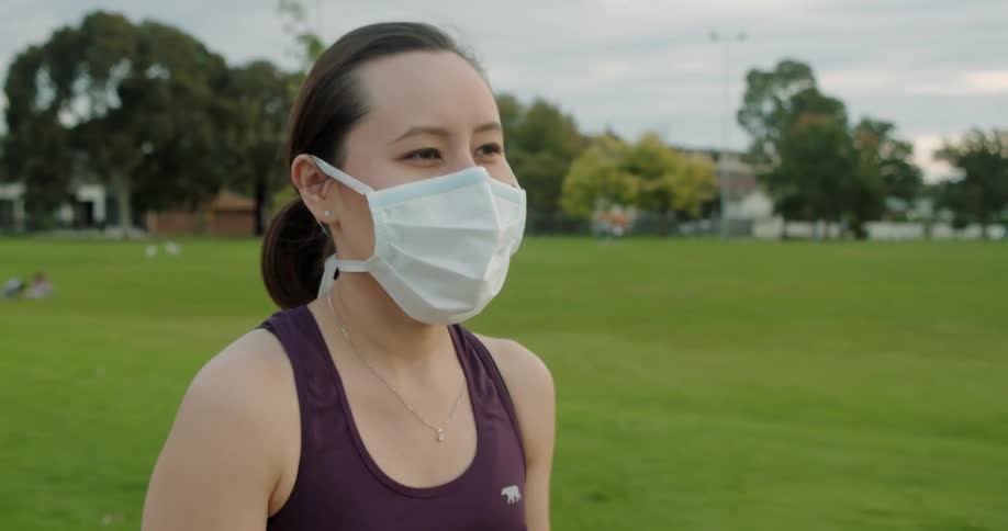 Woman wearing face mask jogging on park at day
