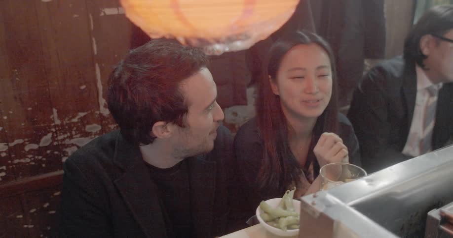 A man and woman talking while sitting in an asian restaurant