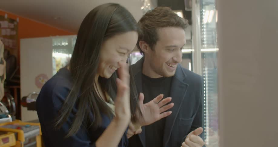 A man and woman laugh as they play a game