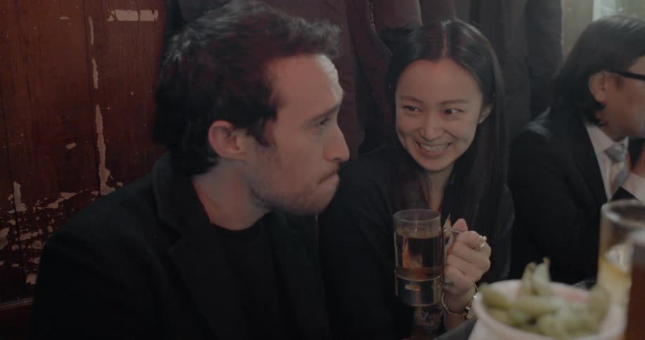 A man and a woman drink hot tea from each others glass on a date