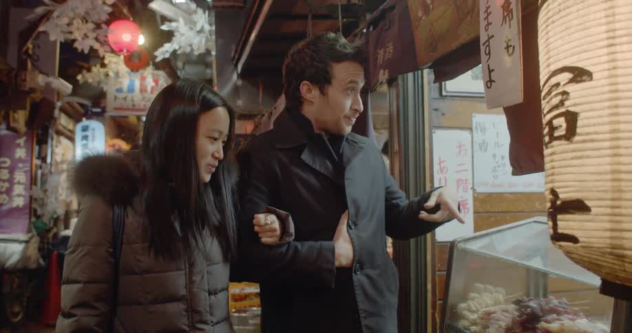 Couple walks arm in arm down narrow city alley in japan