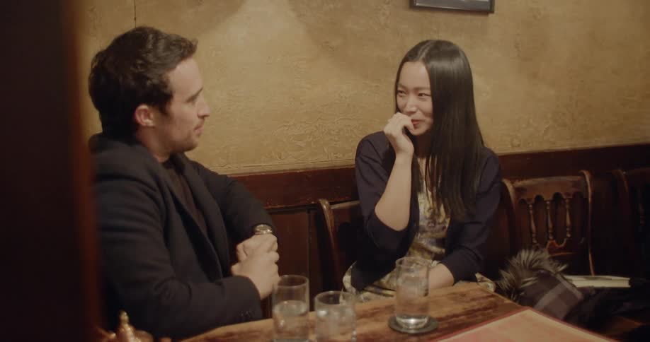 A man and a woman sitting at a table and talking