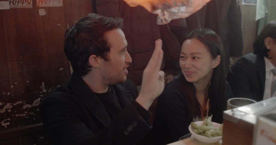 A man and a woman sitting at a table ordering food