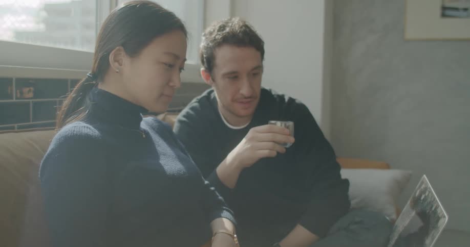 A woman and man look at a laptop