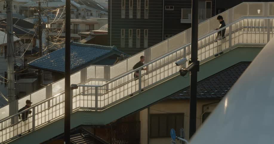 Man running up the stairs of a footbridge in a city at dawn