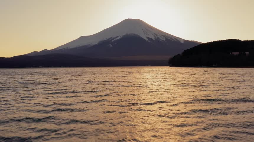 An aerial view of an ocean is displayed by mountains