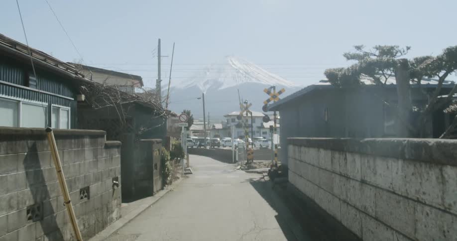 Man walks on the road in the neighborhood in the town with the view of snow capped mountain